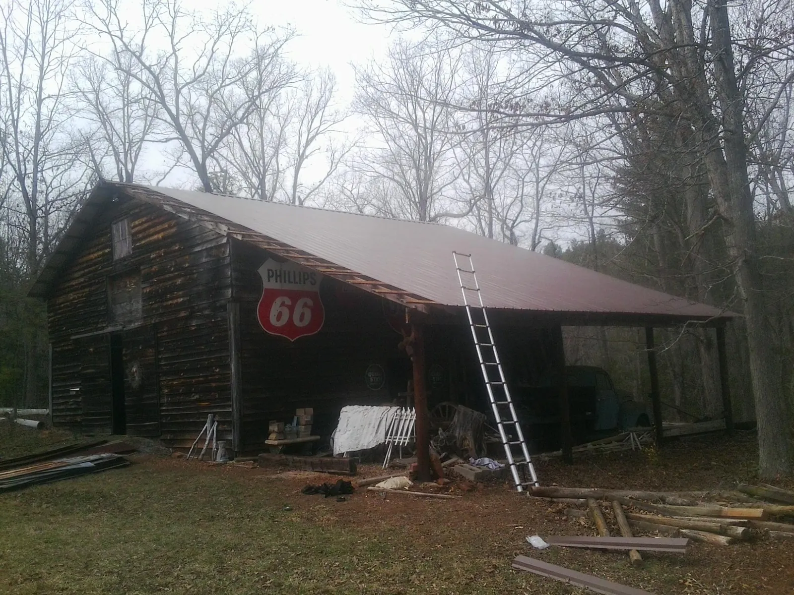 New metal roof on an open sided timber barn with a vintage sign in Osseo