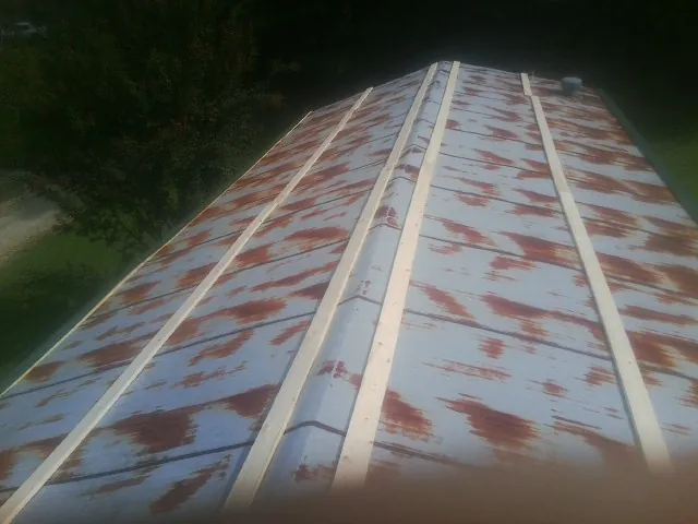 Rusted metal roof panels with new wood purlins before replacement — Storm Damage Roof Repair in Osseo by Roofing Brothers